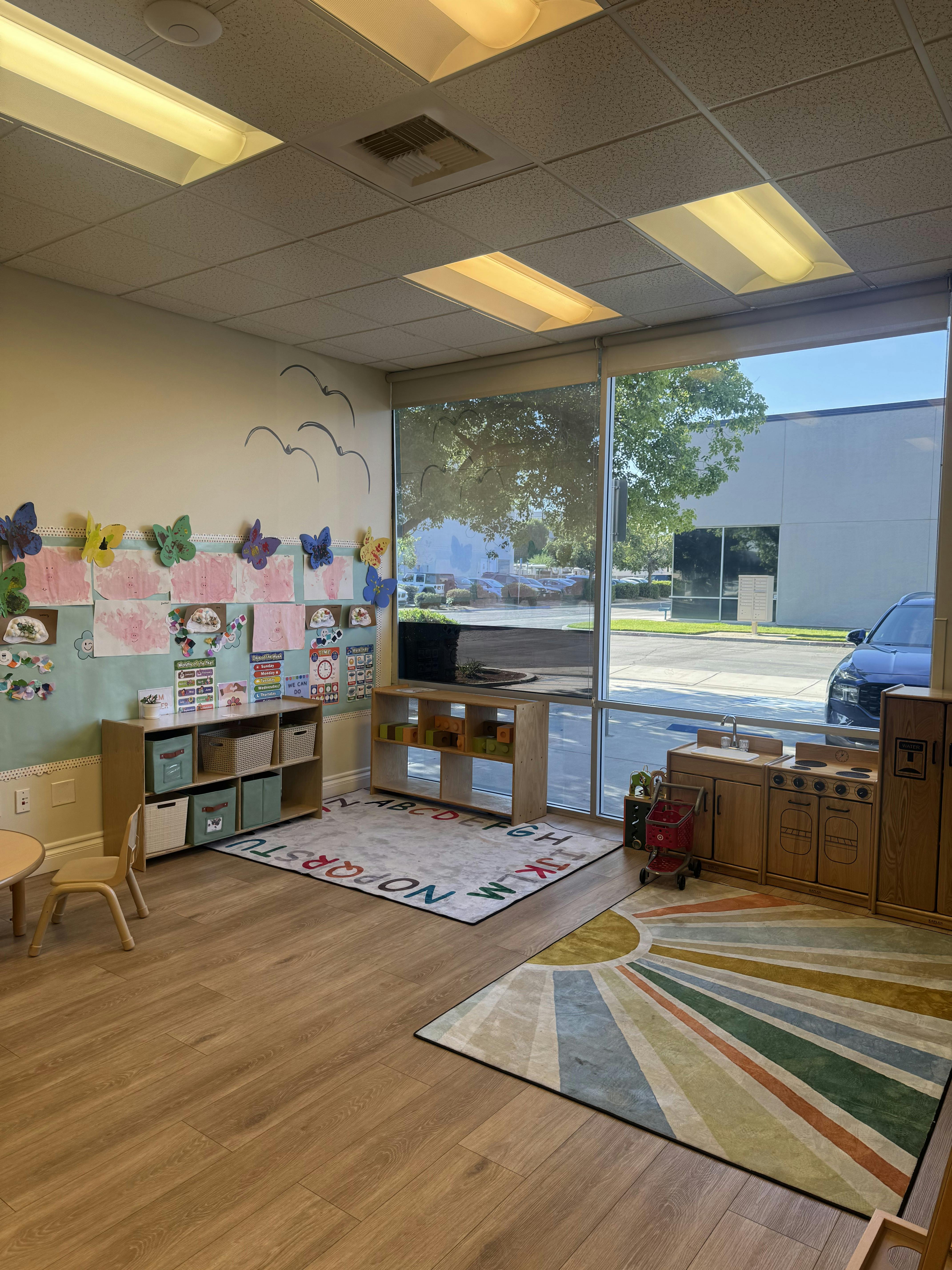 Classroom with child-sized furniture and brightly colored rugs