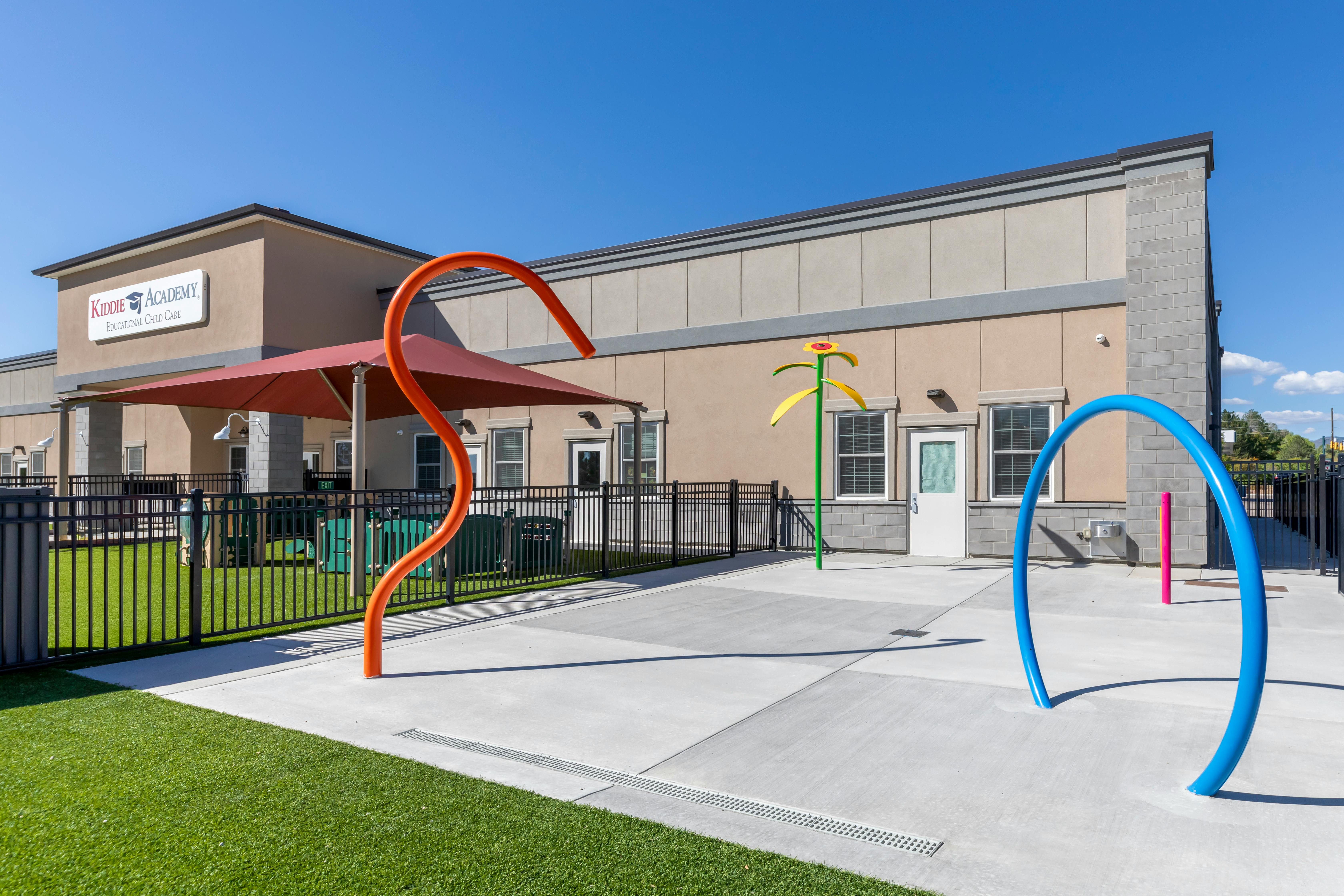 Outdoor play area with water features and a building in the background