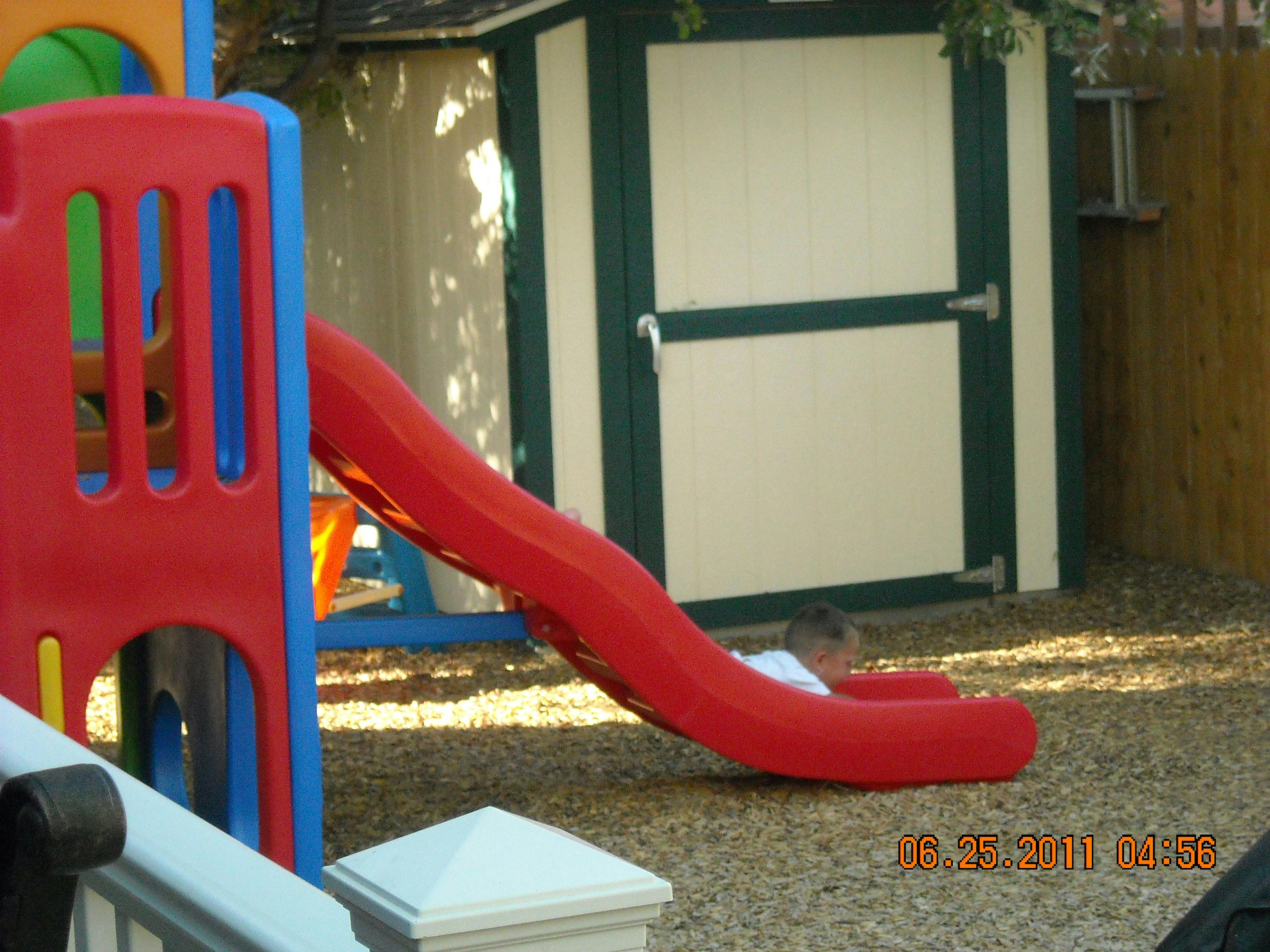 Child at the bottom of a red slide