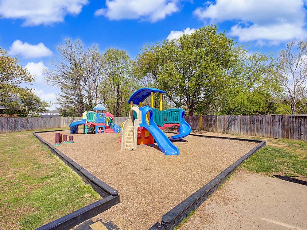 Colorful playground with multiple slides and climbing areas on wood chips