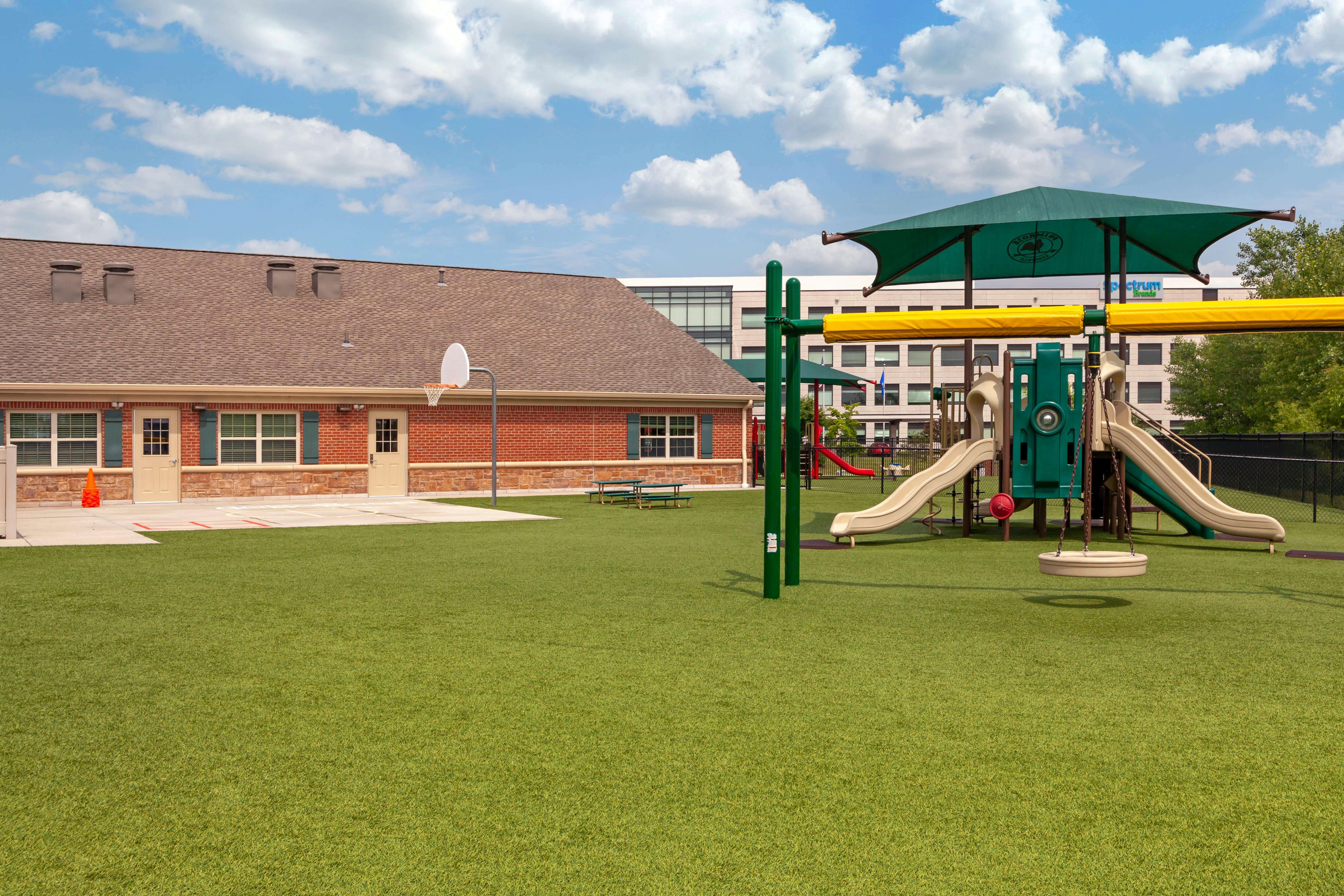 Playground with swings, slides, and climbing structures next to a building