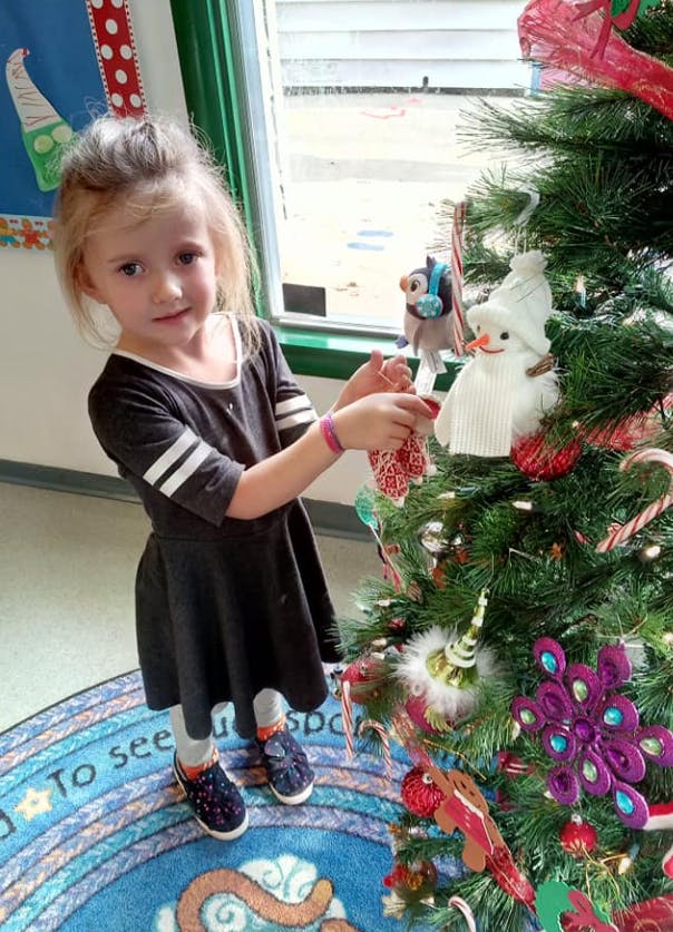 Child decorating a Christmas tree