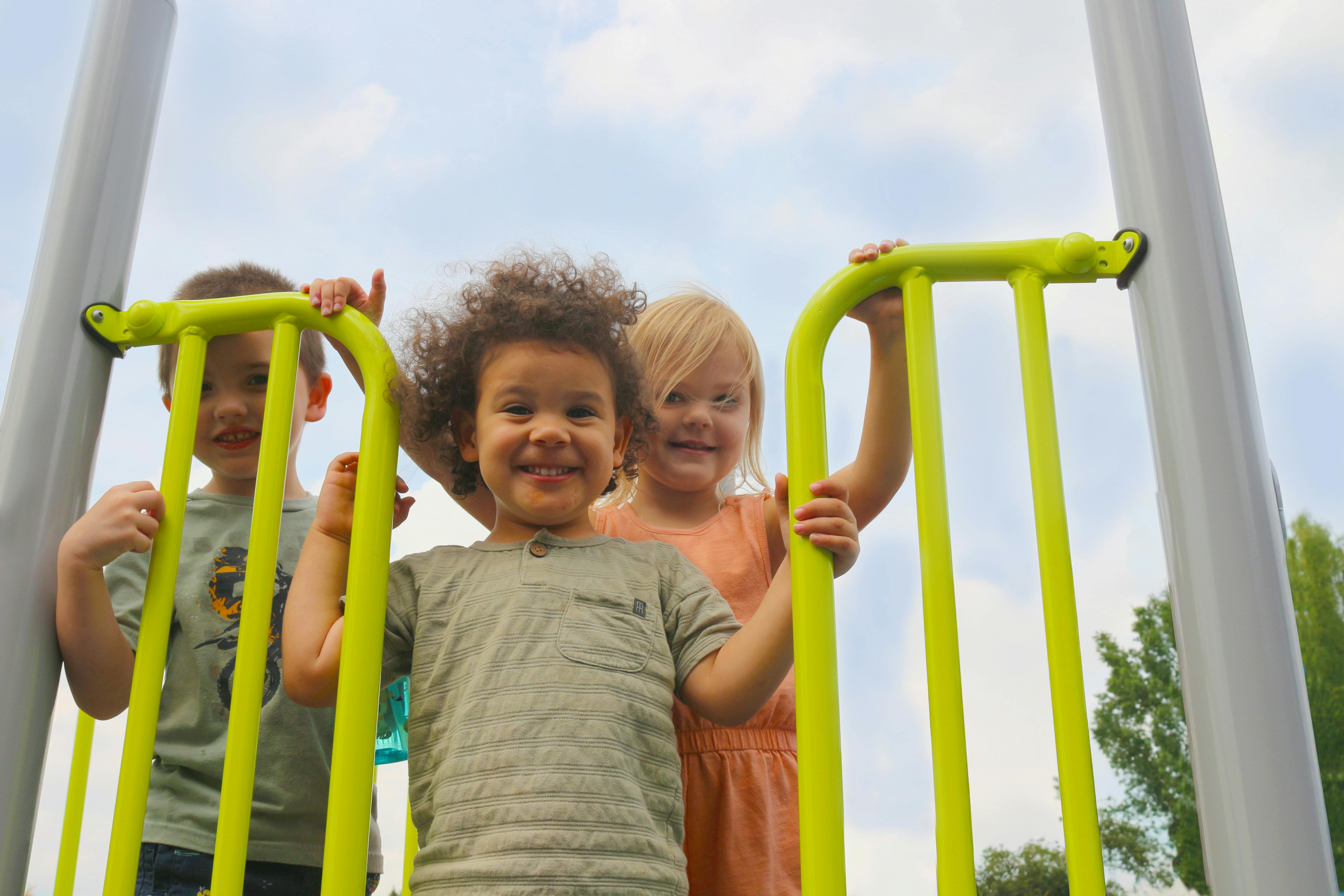 Three children on playground equipment