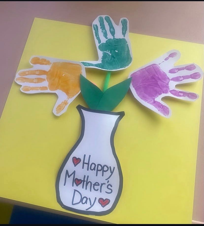 Handprint craft in a paper vase with the text Happy Mother's Day