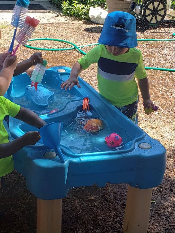 Children playing with a water table outdoors