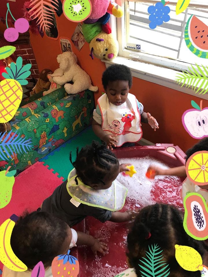Children playing with water and toys in a sensory bin