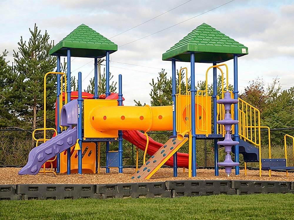 Colorful playground with slides, climbing walls, and tube