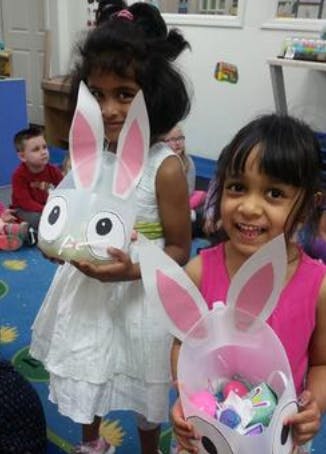 Two children holding bunny-shaped containers