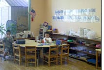 Two children sitting at a table in a classroom