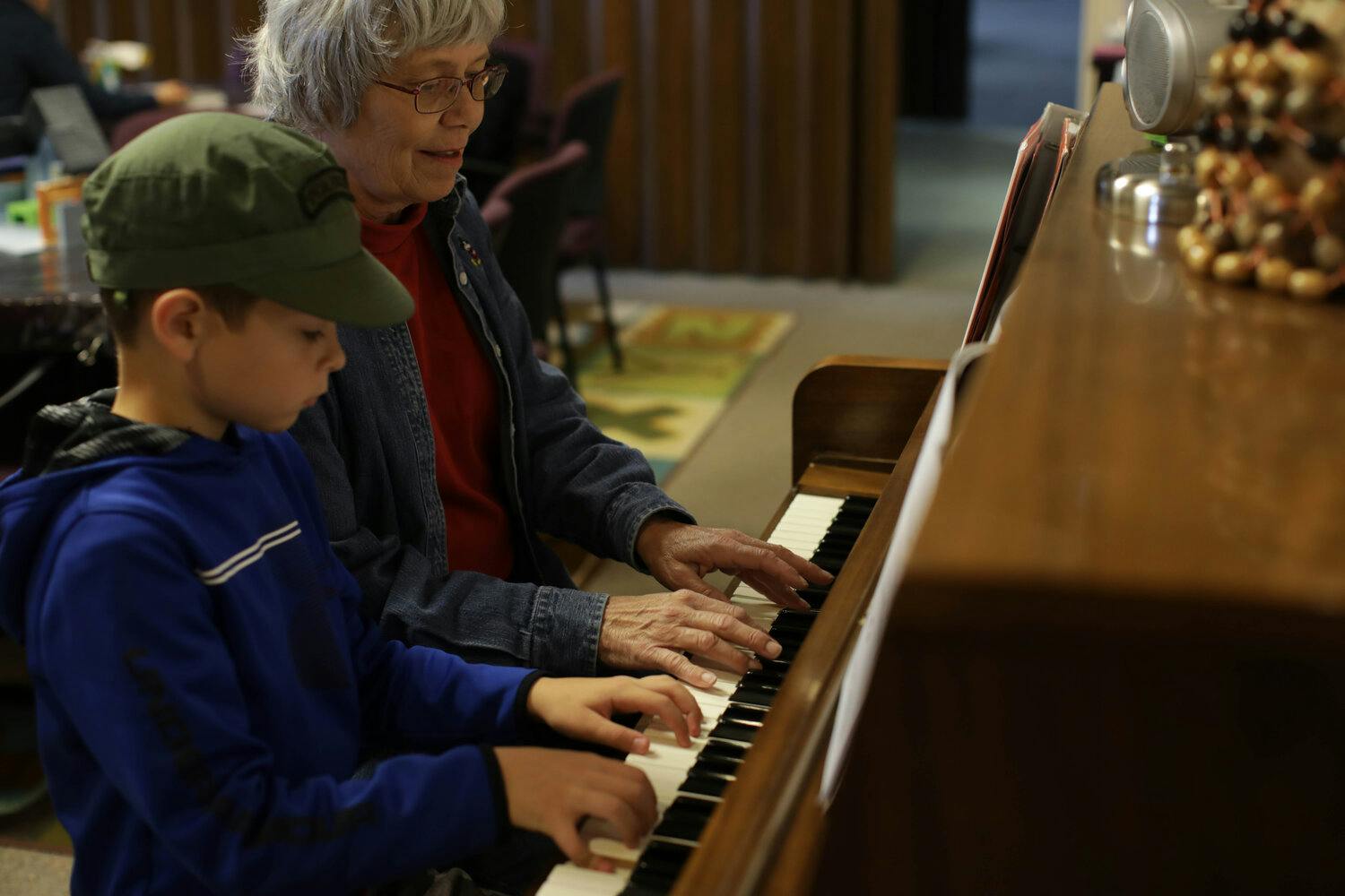 Adult and child playing piano together