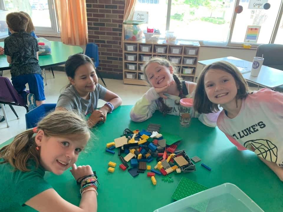 Four children at a table with building blocks