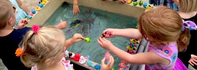 Children playing with toys in a water table