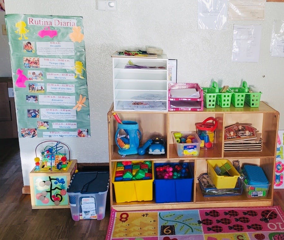Classroom with a routine chart on the wall and shelves filled with toys