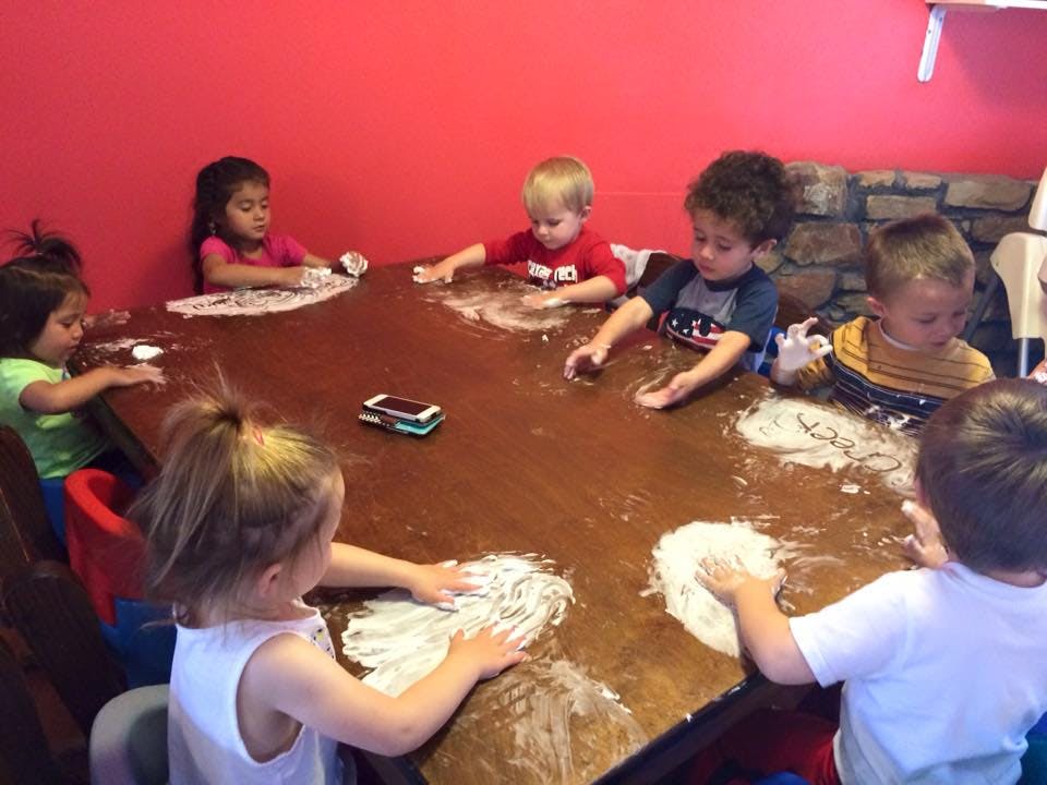 Children playing with flour on a large table