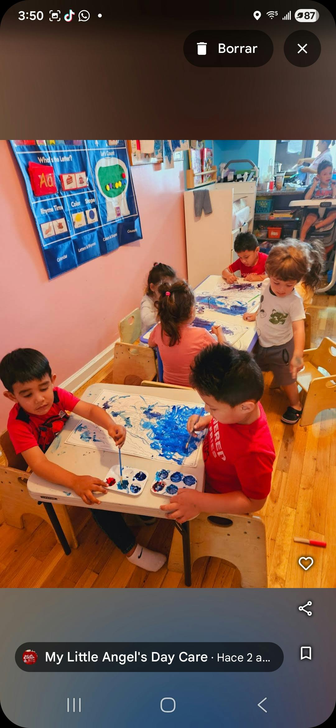 Children painting at tables in a classroom
