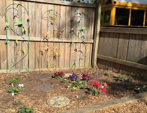 Flower garden with a wooden fence and metal trellises