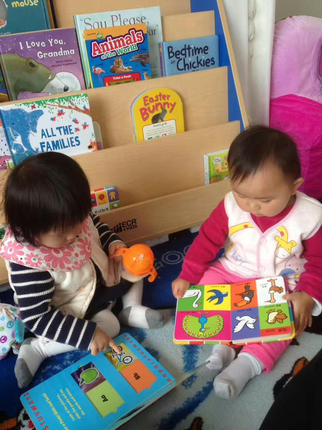 Two children sitting on the floor with books