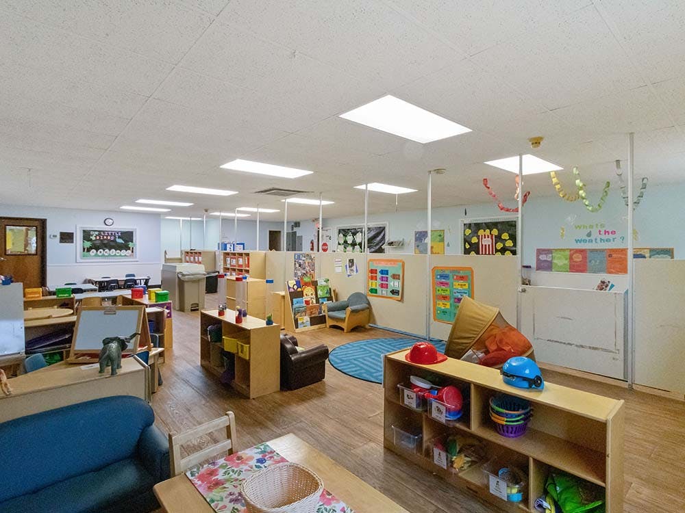 Classroom filled with child-sized furniture and learning stations