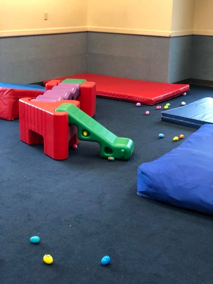 Indoor play area with colorful soft play equipment and mats
