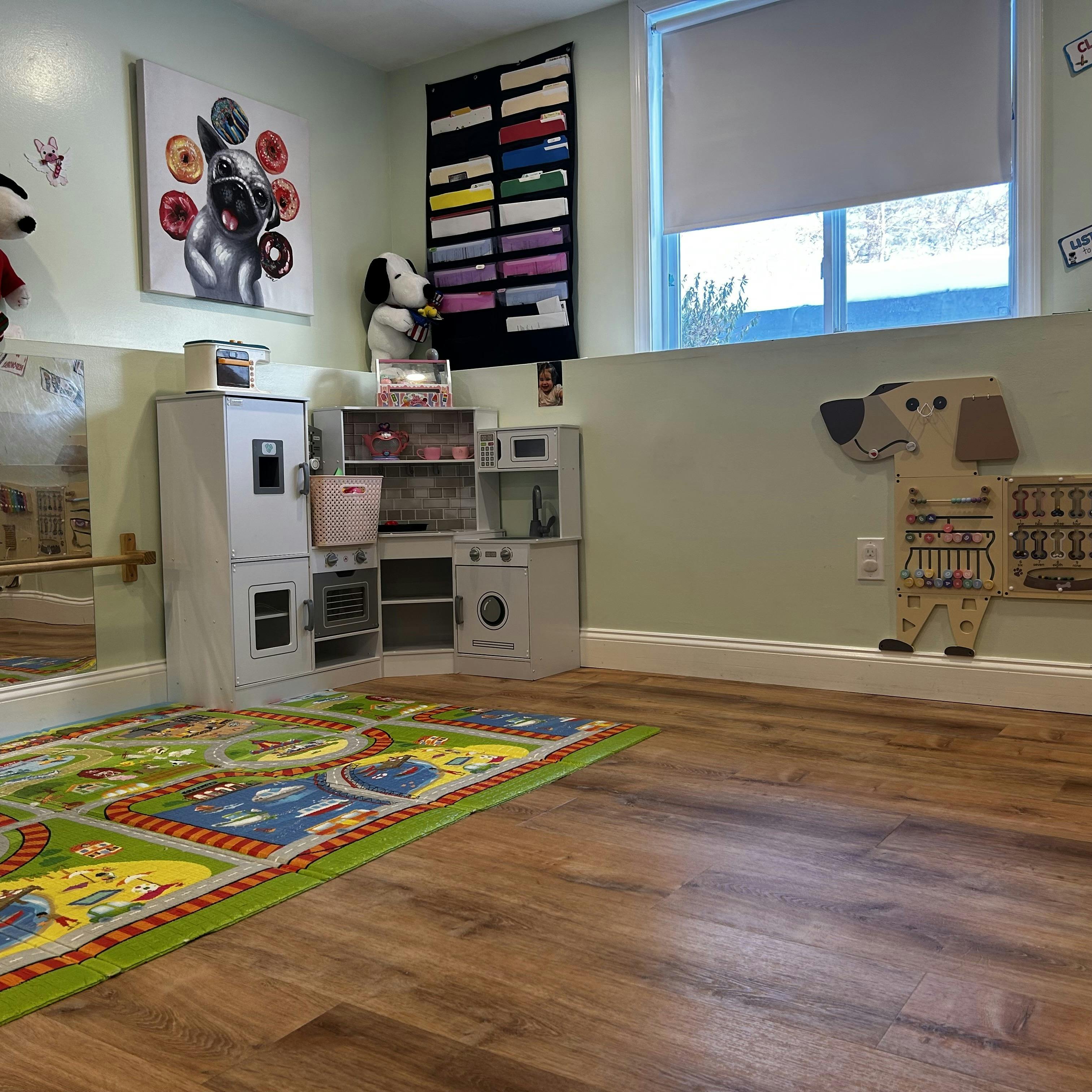 Playroom with toy kitchen, road map rug, and dog-shaped activity board