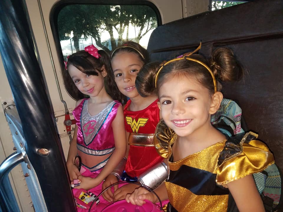 Three children in costumes sitting together