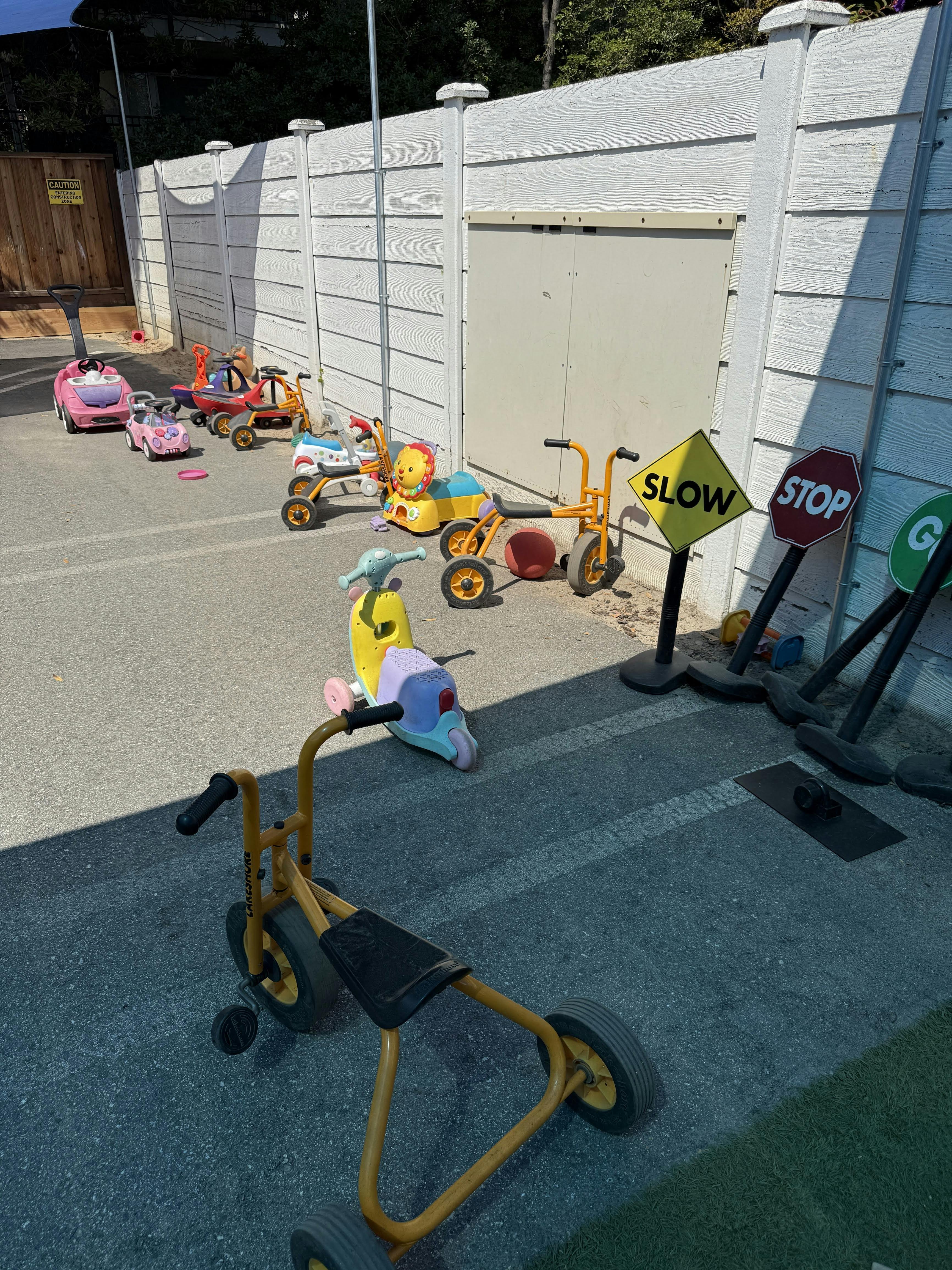 Children's ride-on toys and traffic signs on pavement