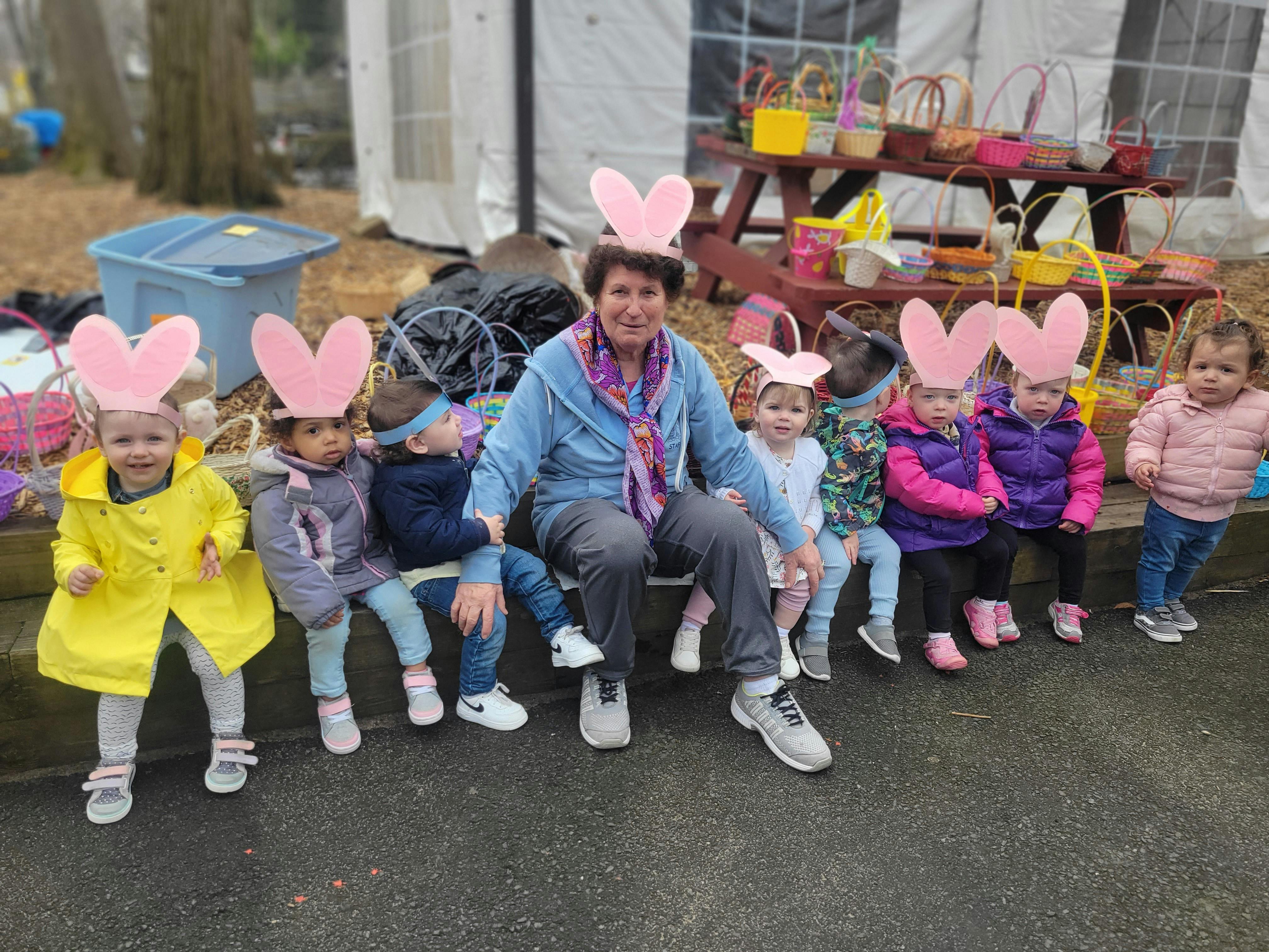 Person sitting with multiple children wearing bunny ears