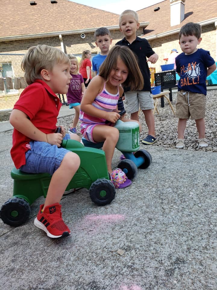 Children playing outdoors with ride-on toys
