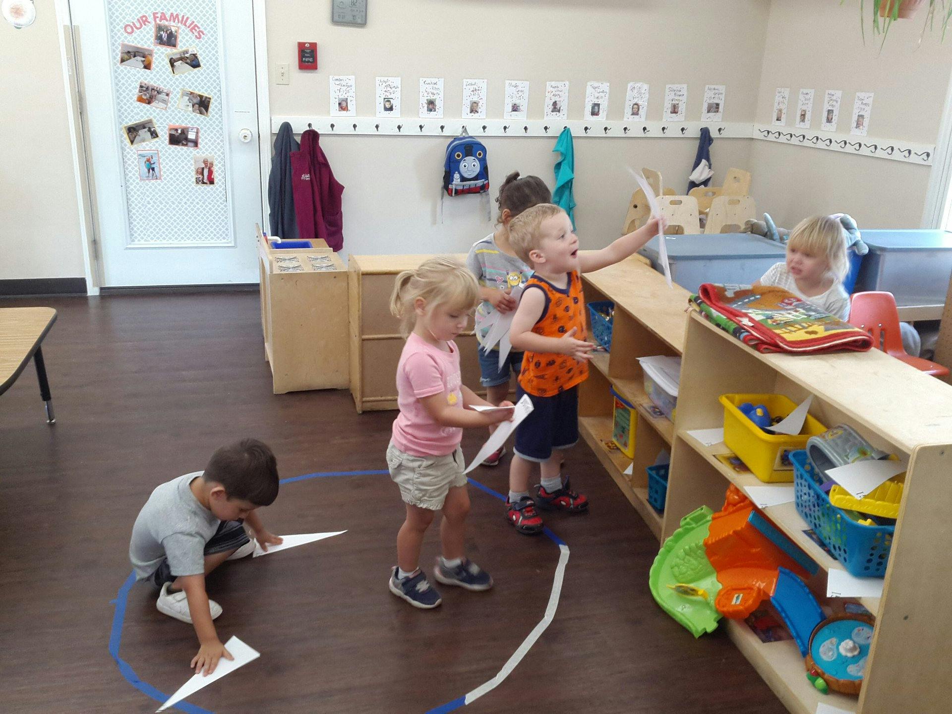 Children playing with paper in a classroom