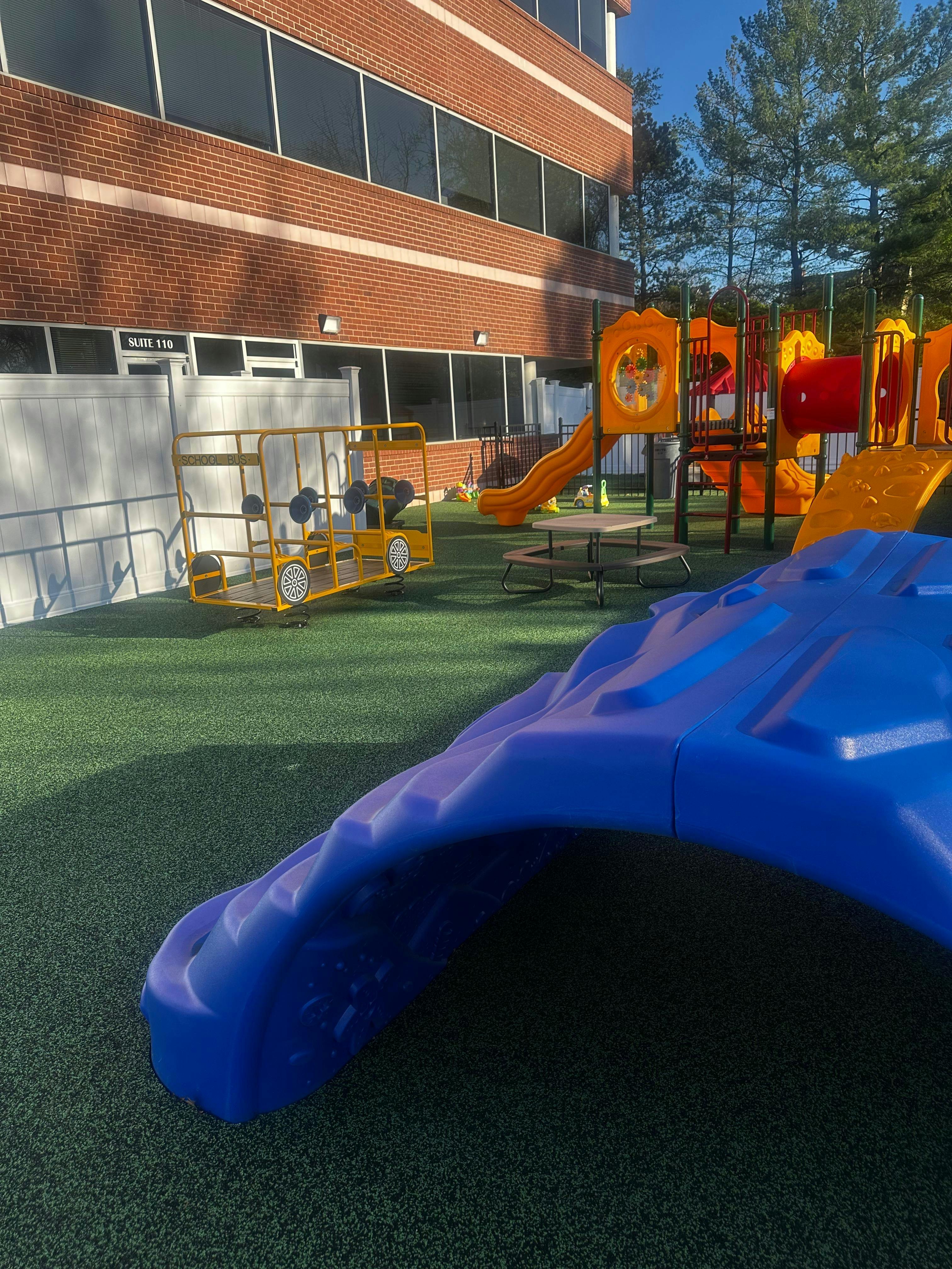 Playground with colorful slides and climbing structures on green turf