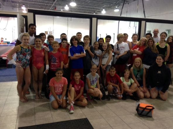 Large group of children and adults posing together indoors