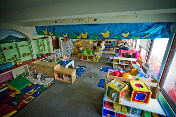 Playroom with toys, shelves, and a colorful rug