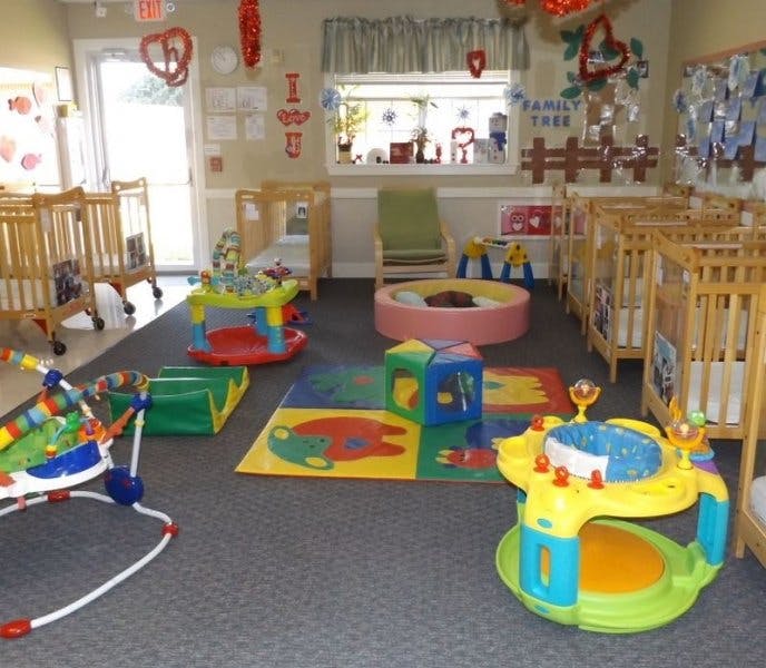 Nursery room with multiple cribs, play mats, and baby activity centers