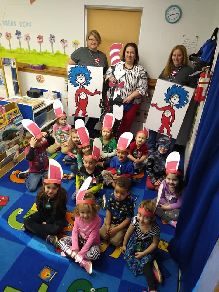 Adults and children in a classroom, some wearing bunny ears