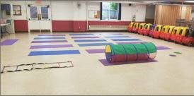 Exercise mats on a floor with a play tunnel and agility ladder