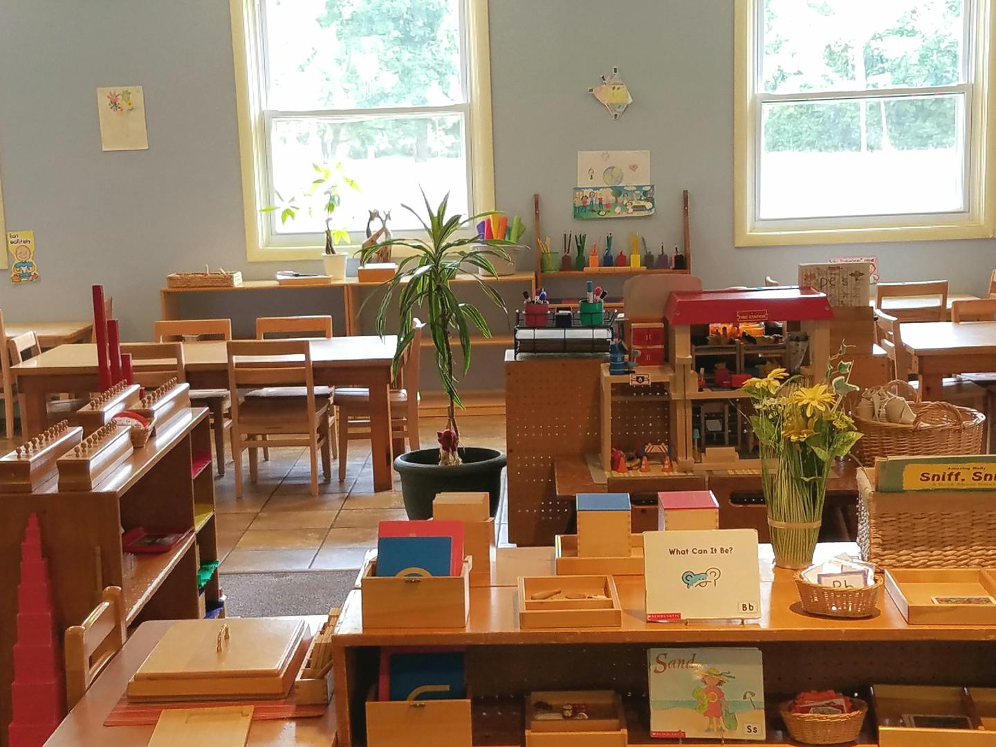 Classroom with wooden tables, chairs, and learning materials