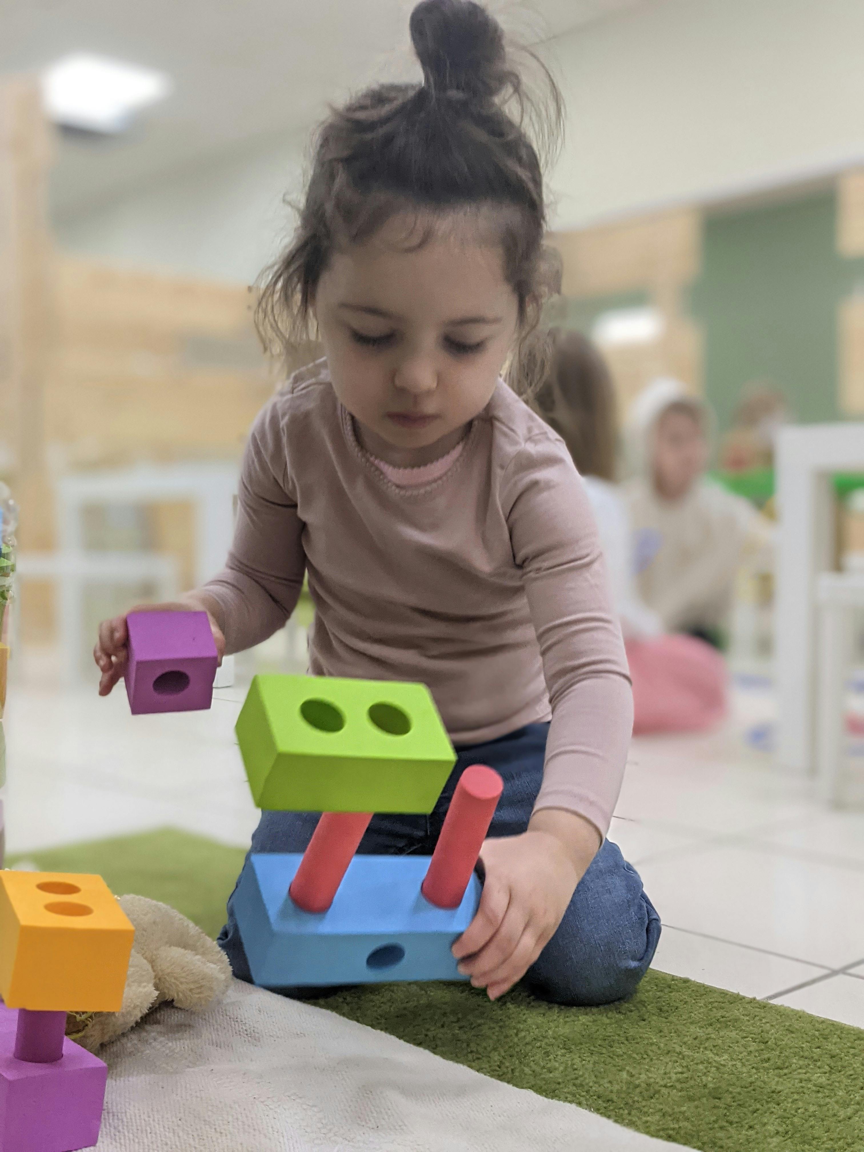 Child playing with colorful wooden block toys