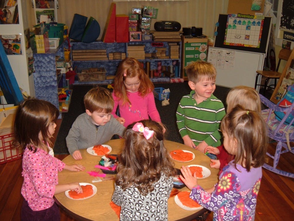 Children gathered around a table with plates
