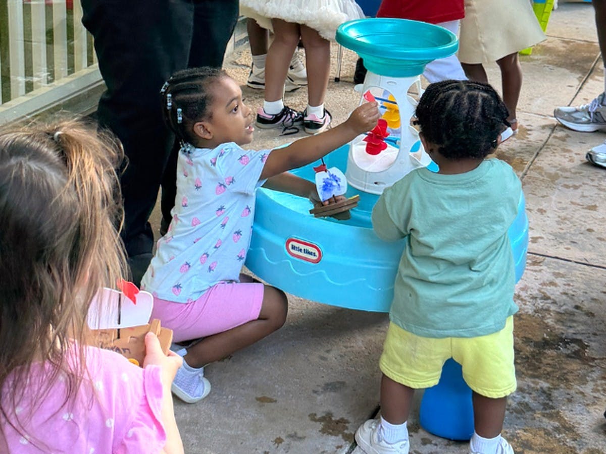 Children playing with a water table and toy boats