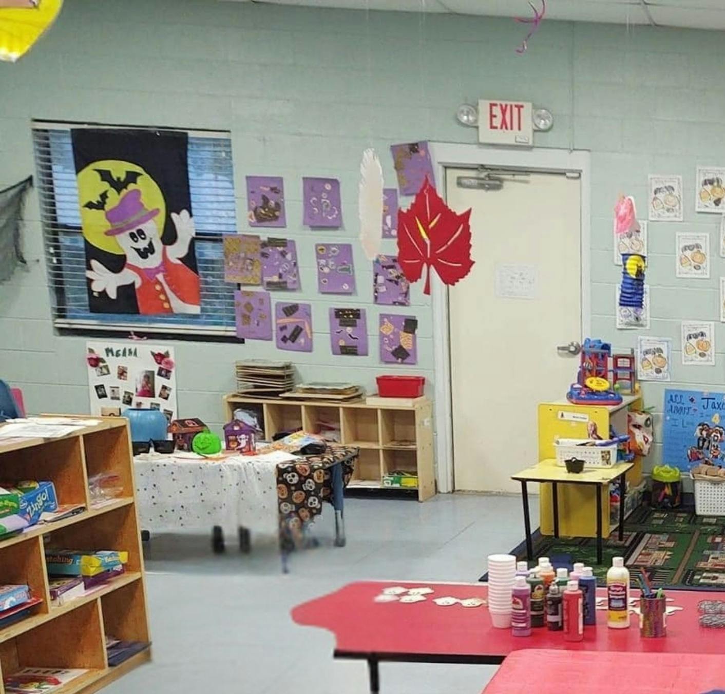 Classroom decorated with Halloween and fall themes, with an exit sign over a door