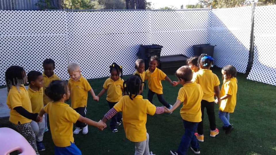 Children holding hands in a circle on a playground