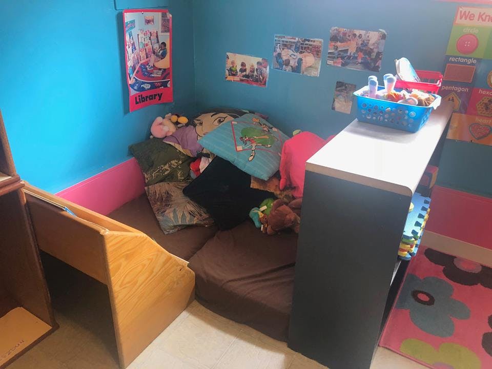 Small room with blue walls, a brown mattress, and a wooden desk