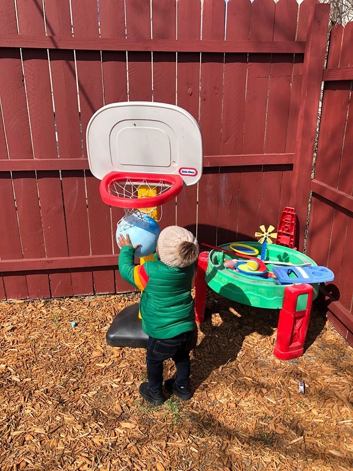 Child playing with a toy basketball hoop