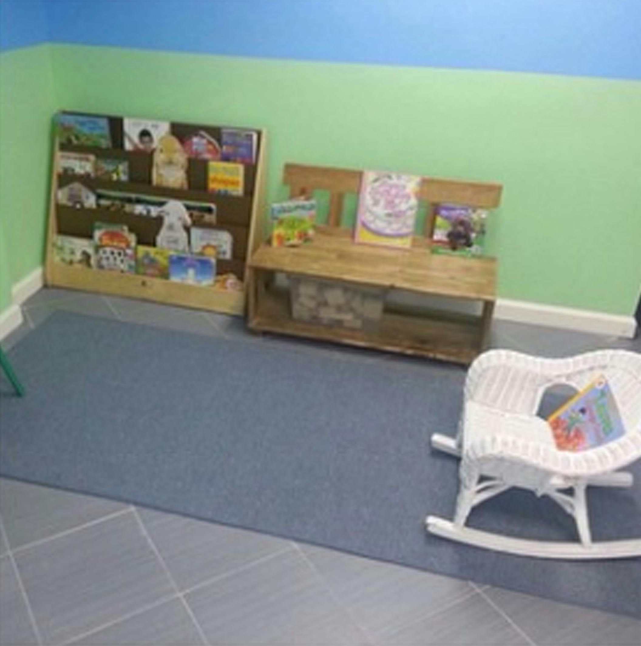 Bookshelves with books and a white rocking chair in a room