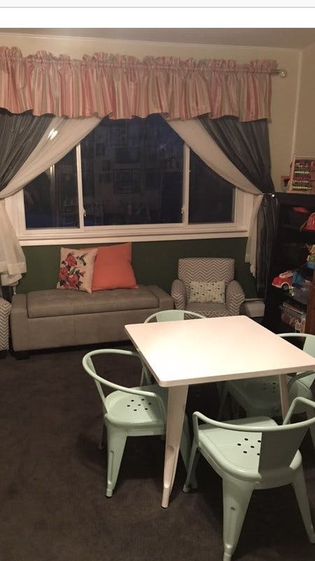 Small white table with four light green chairs in a room