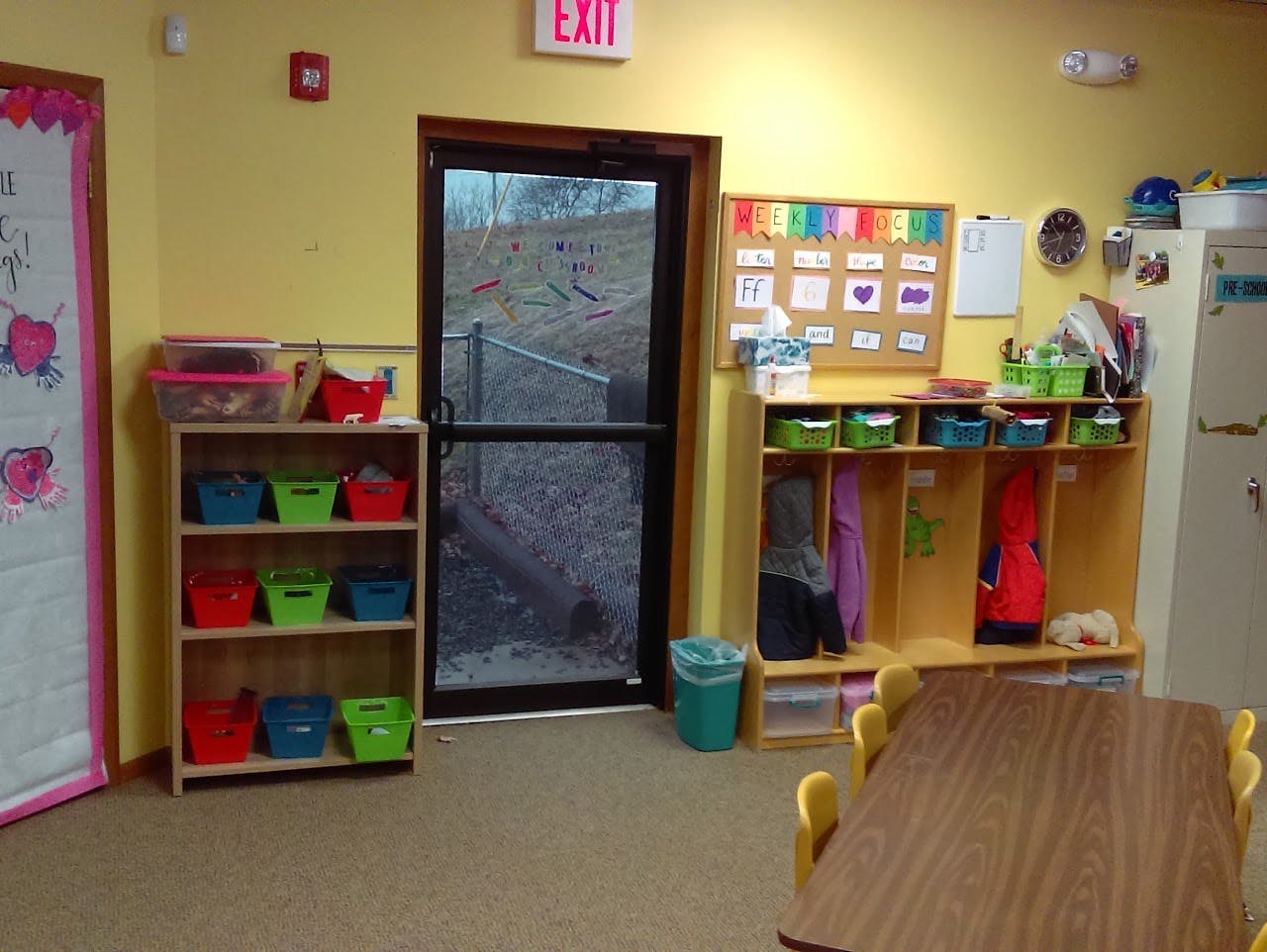 Classroom with cubbies, shelves, and a table with chairs