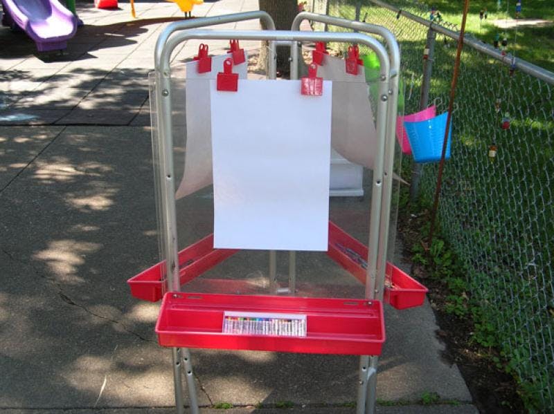 Easel with blank paper and art supplies