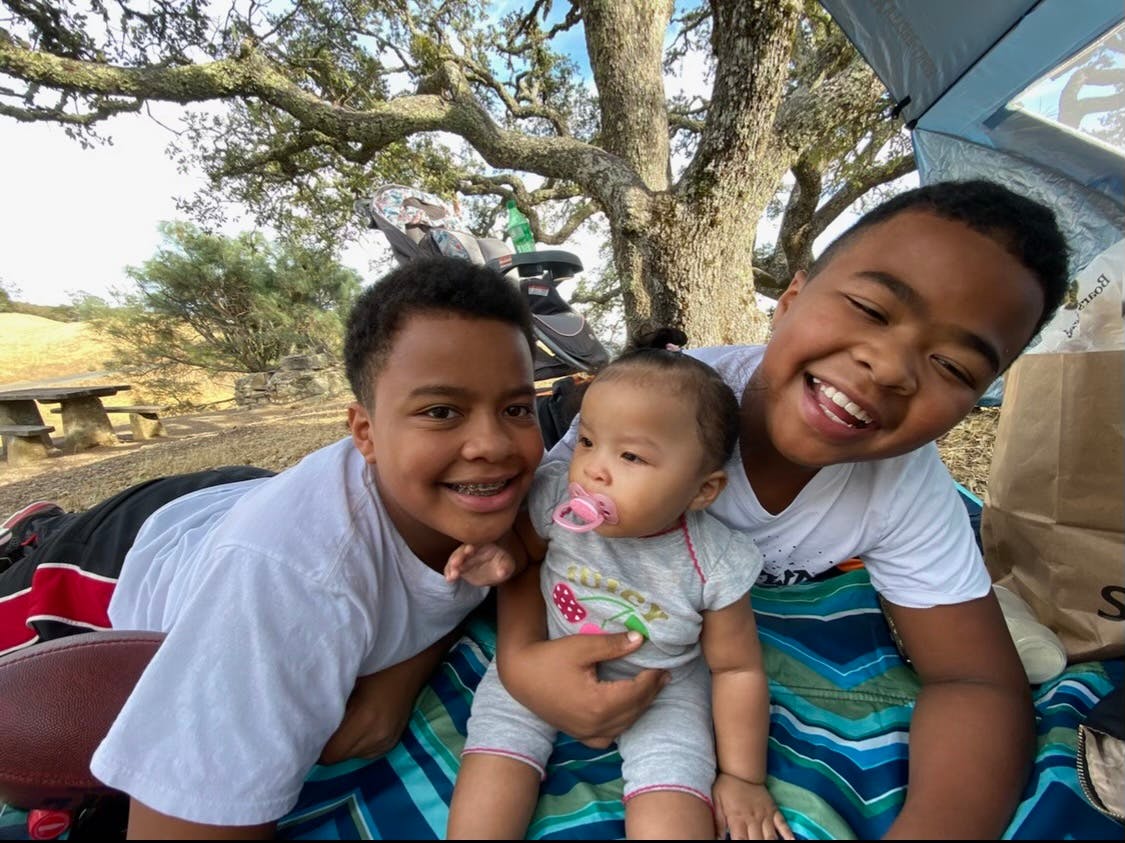 Two teens and a baby with a pacifier