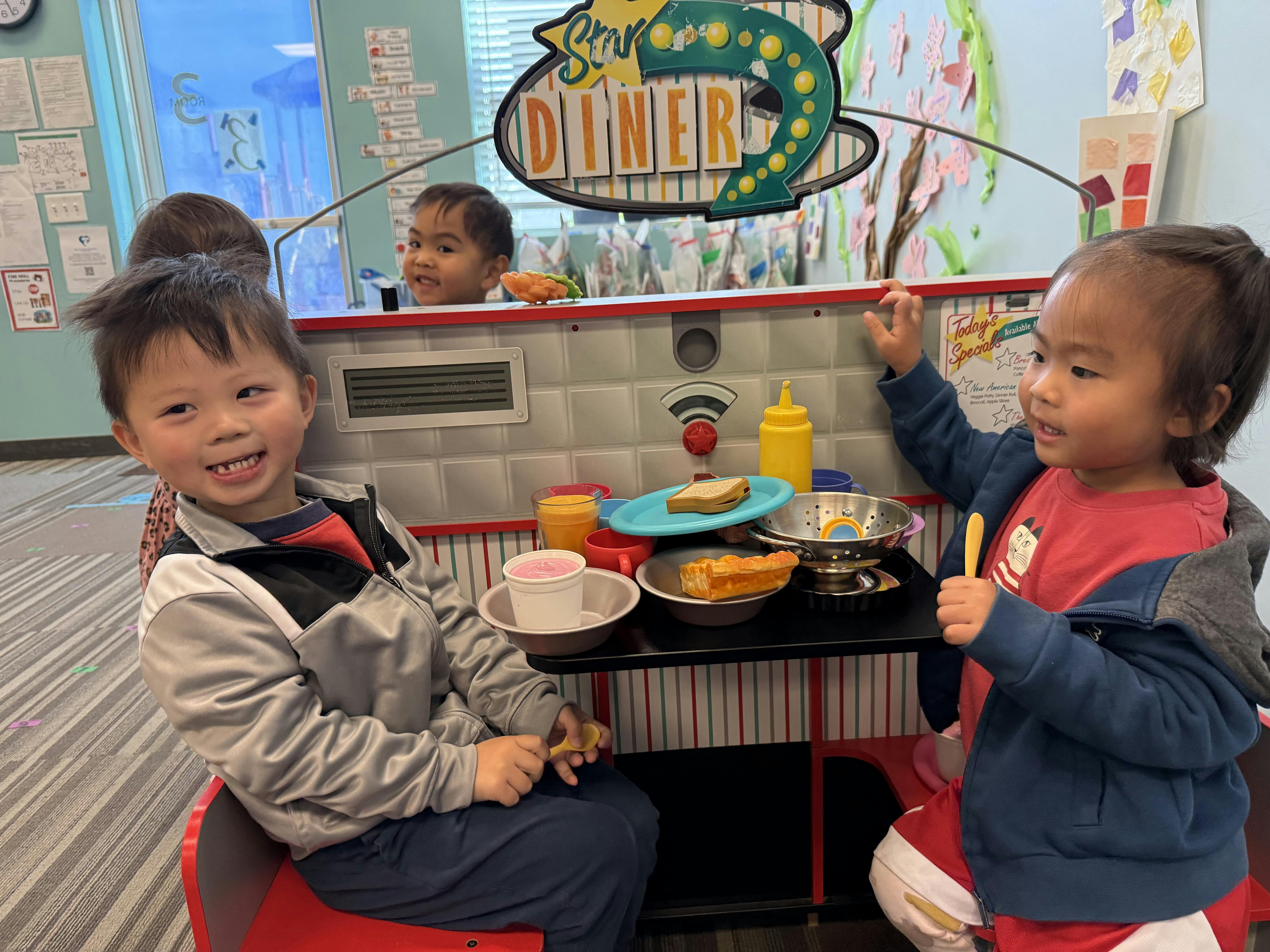 Children playing with a toy diner set