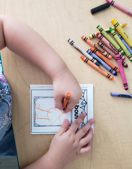 Child coloring a picture with a crayon